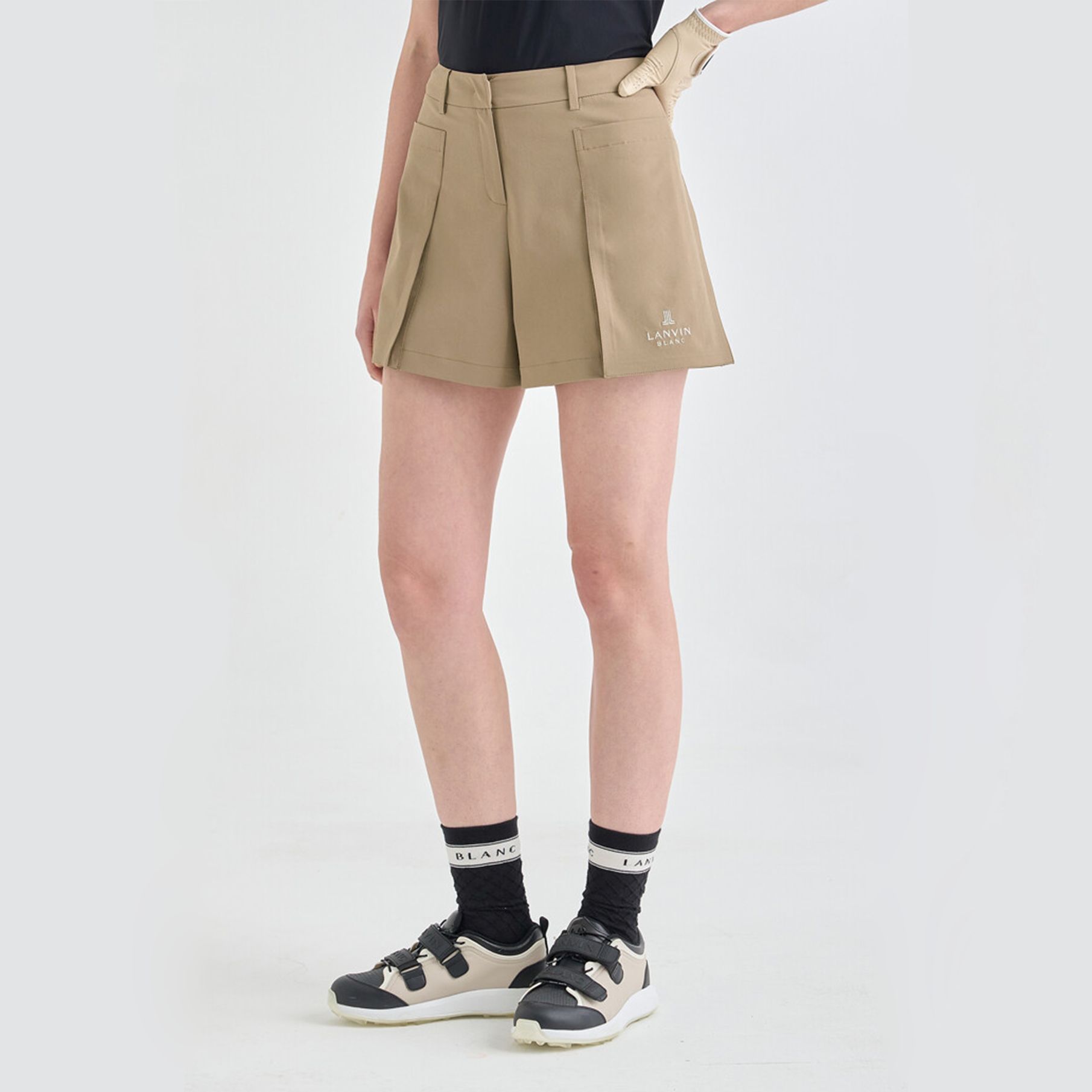 Person wearing beige shorts on a white background
