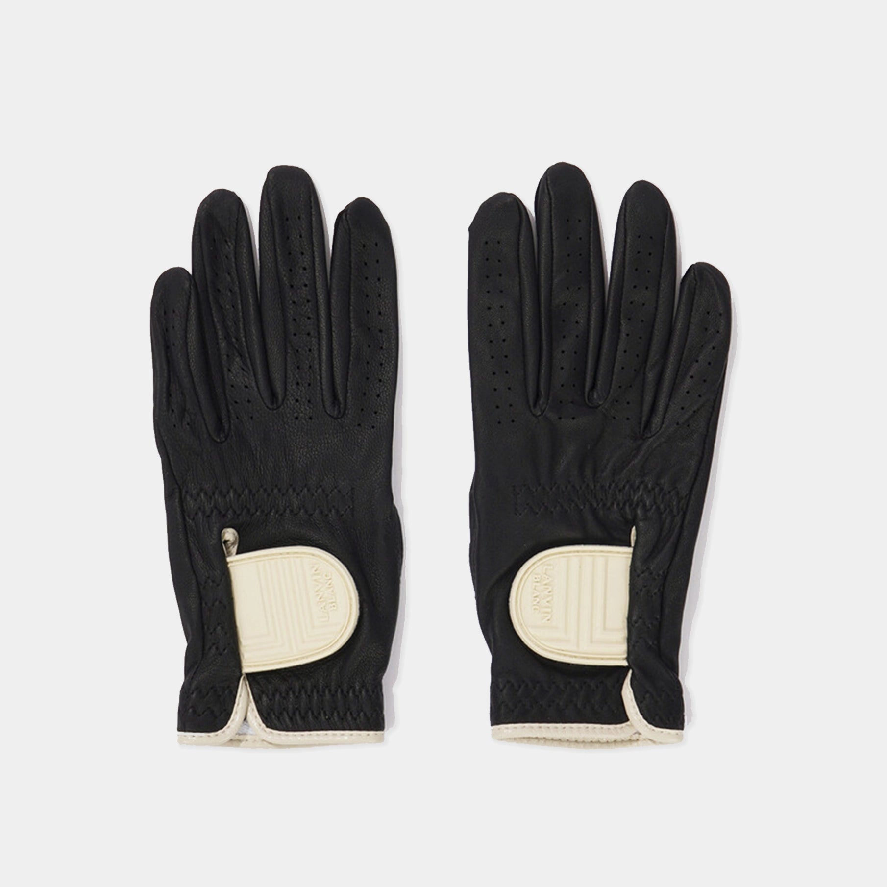 Pair of black gloves with beige accents on a light gray background