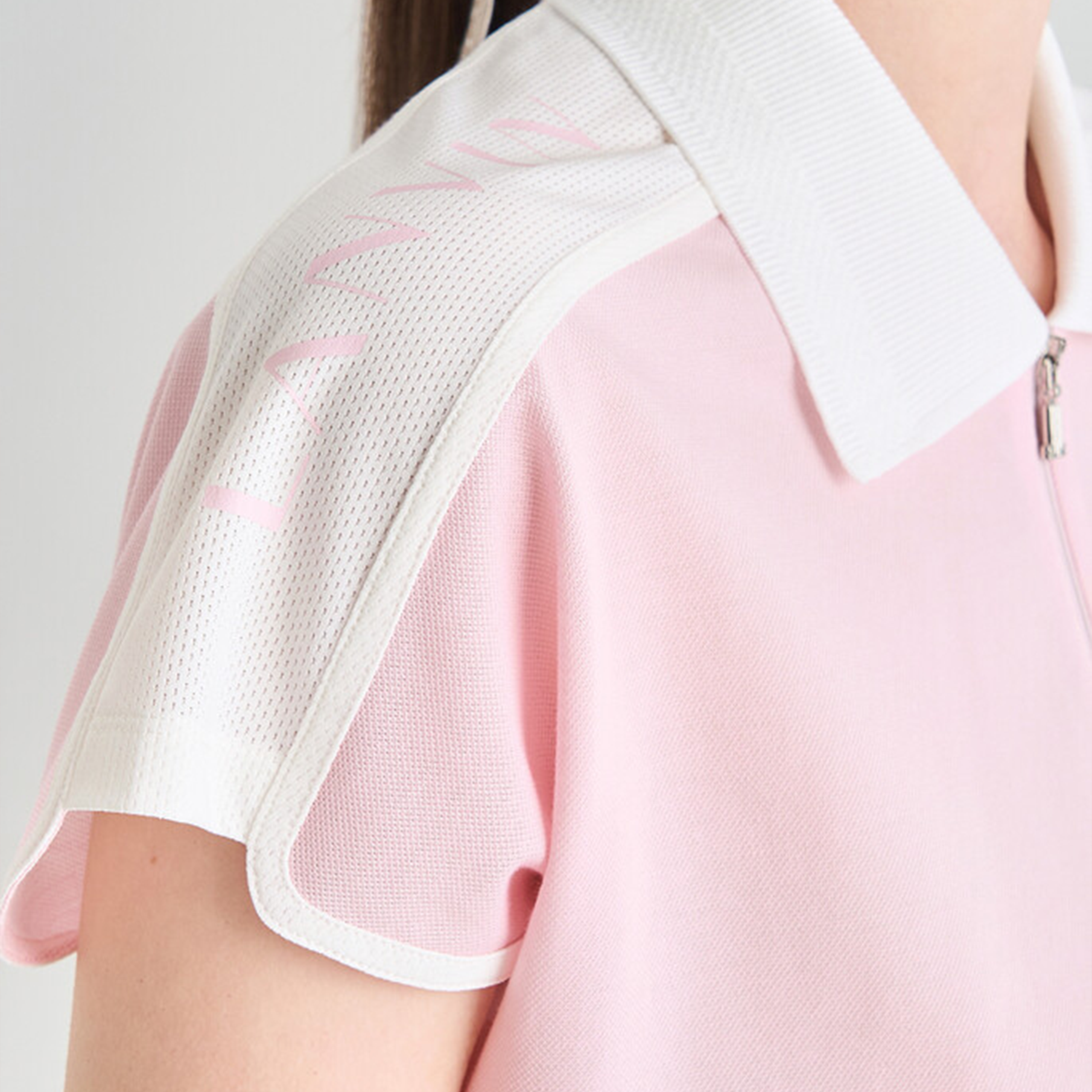 Close-up of a pink and white outfit with mesh detailing on a plain background