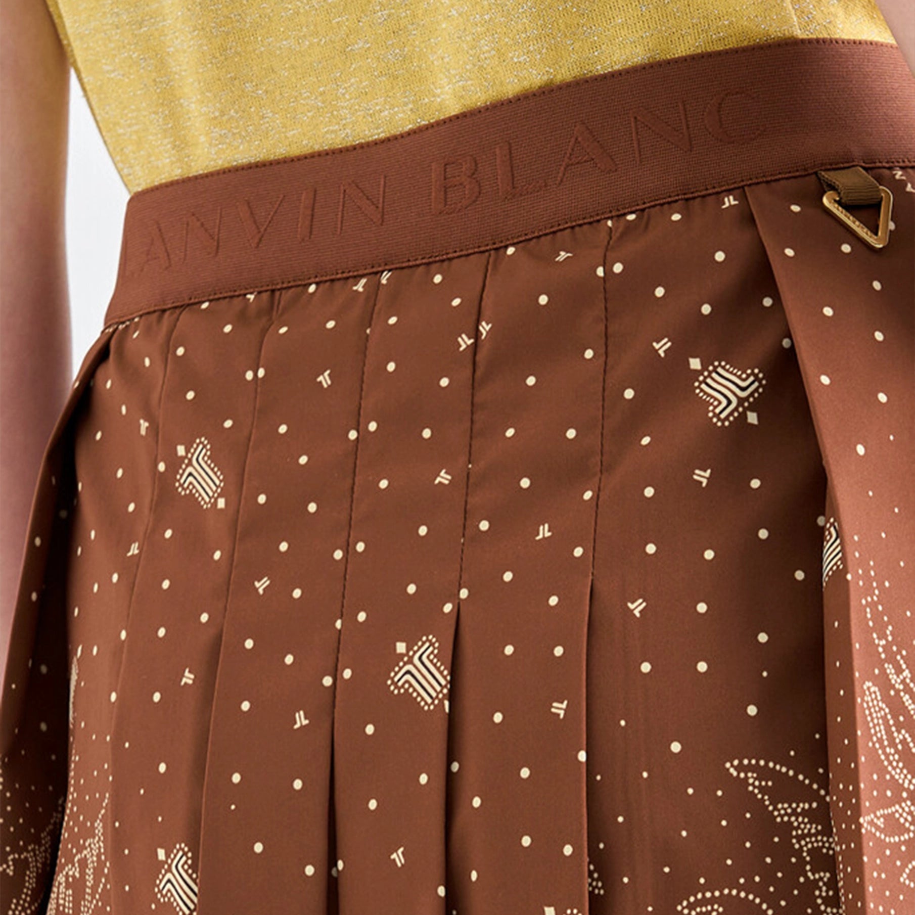 Brown polka dot skirt with a visible brand name on a blurred background