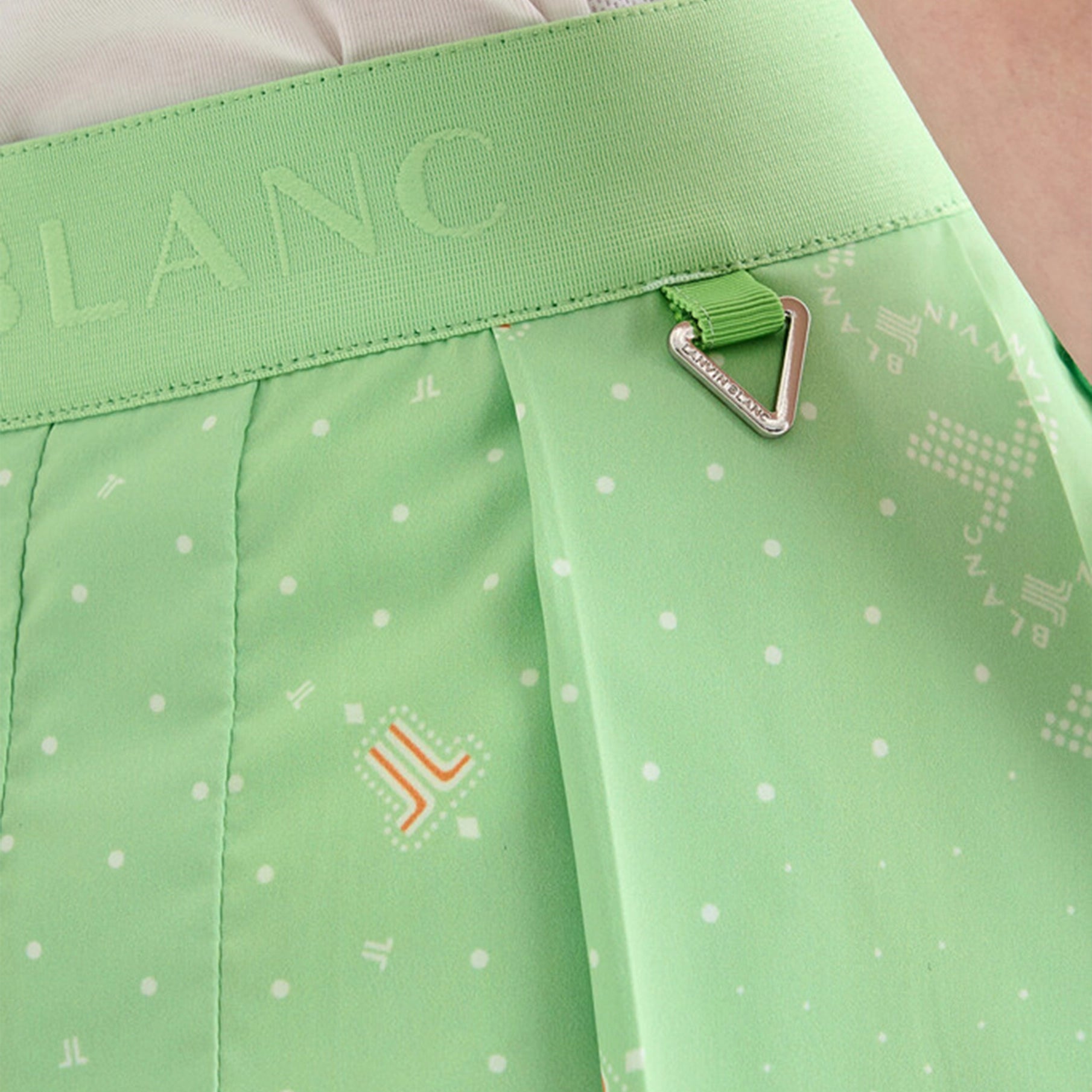 Green shorts with a pattern and brand logo on a light background