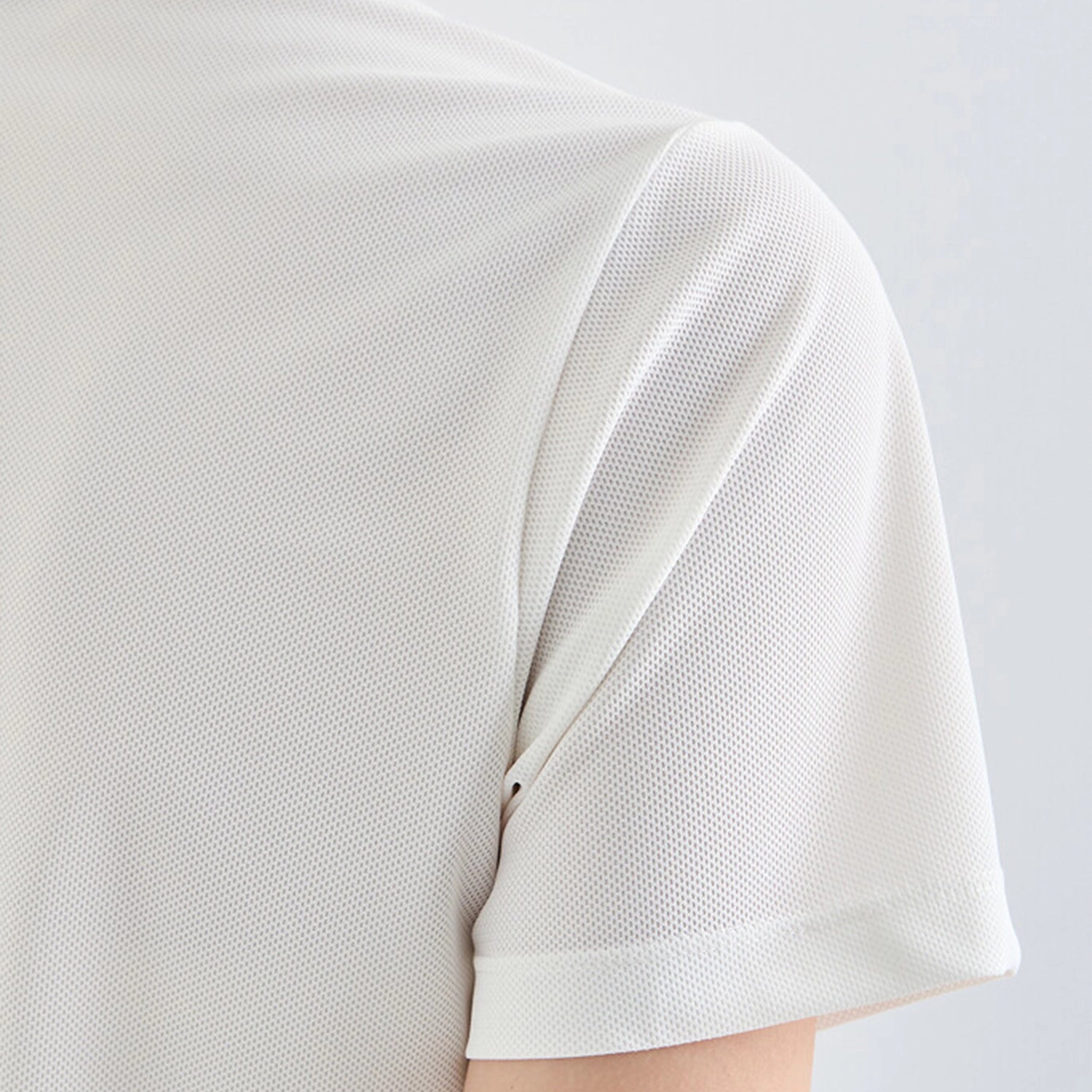 Close-up of a white textured shirt on a light gray background
