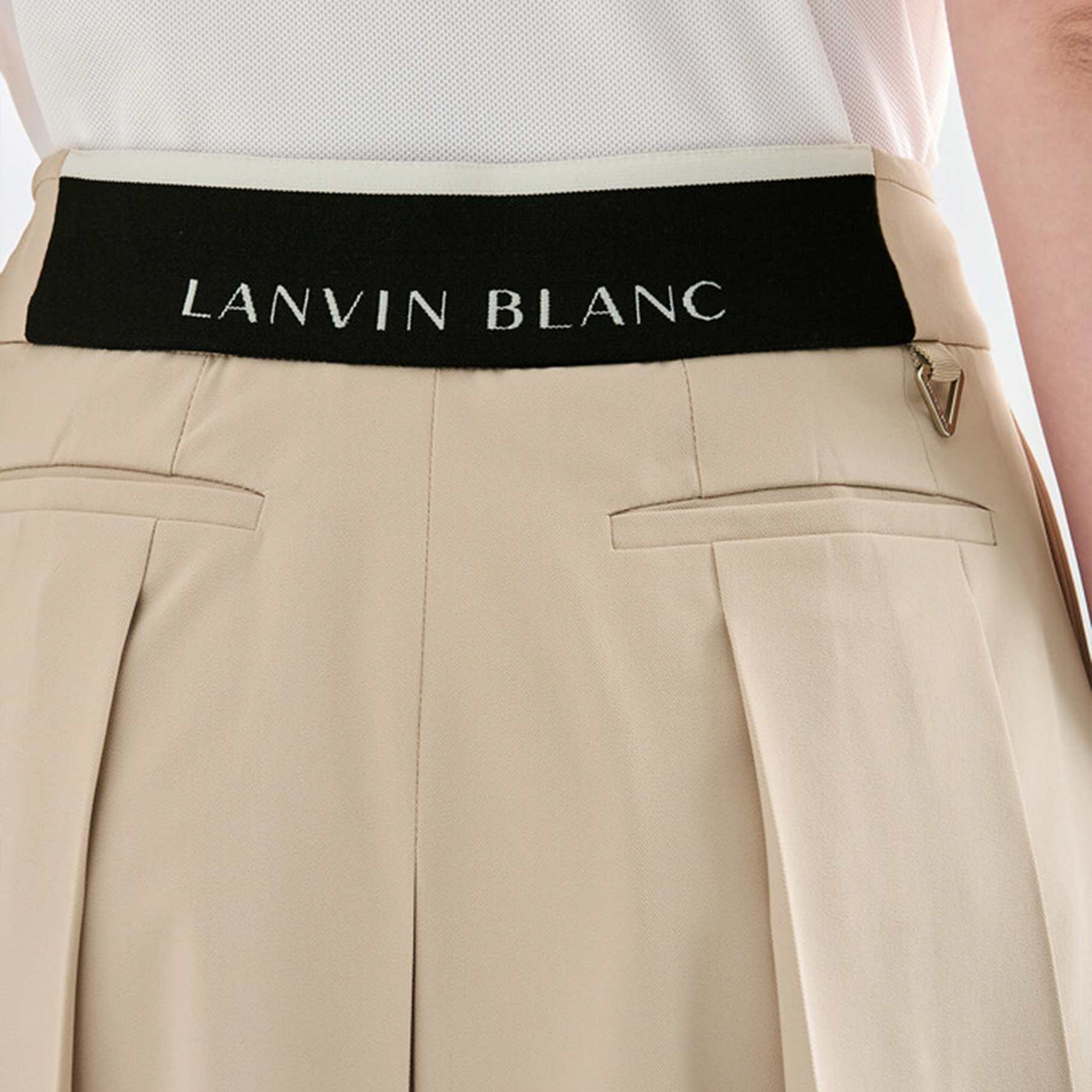 Beige pants with a black belt displaying 'LANVIN BLANC' branding.