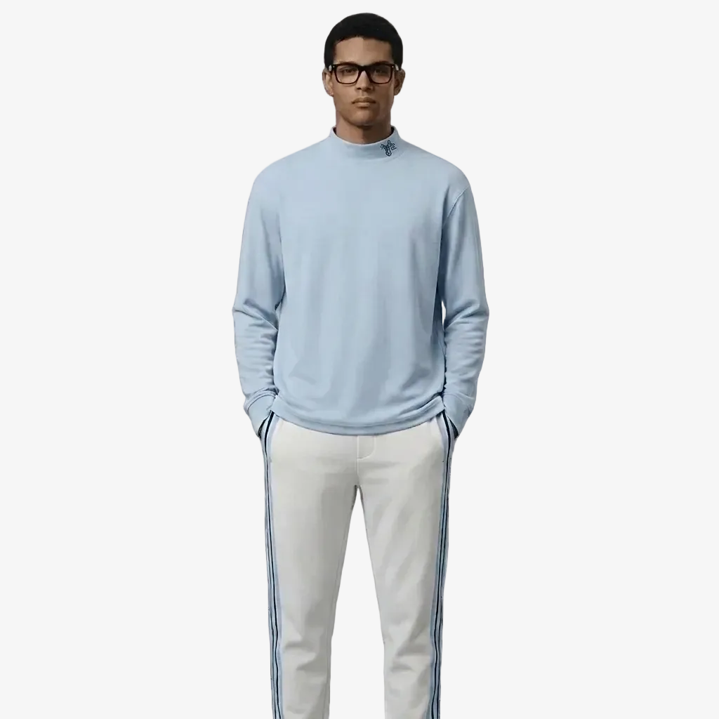 Man wearing a light blue sweater and white pants with stripes on a white background