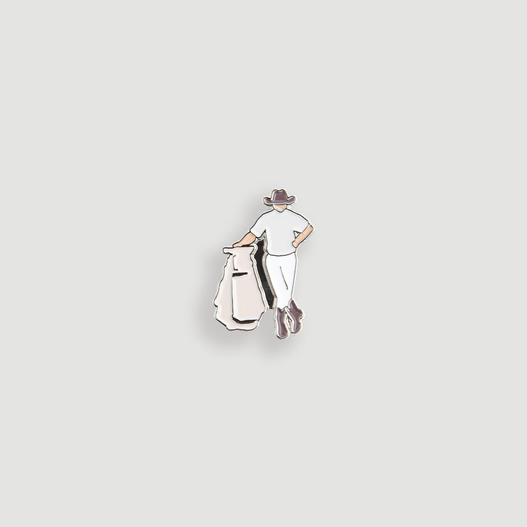 Cream enamel figural ball marker pin showing golfer from behind carrying bag on the green - Laclavi Golf