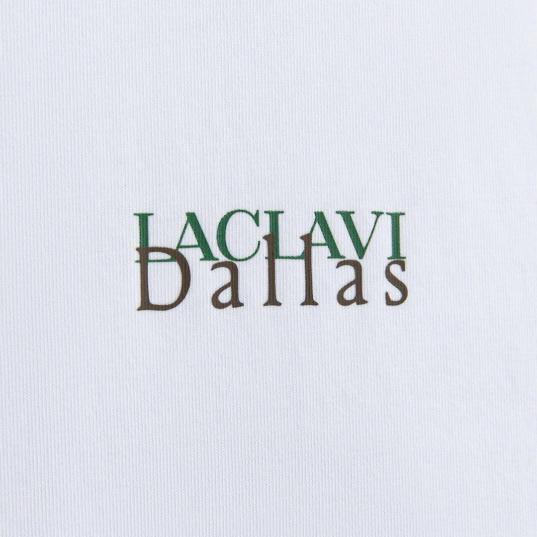 Close-up of LACLAVI Dallas typography print detail on white city edition golf t-shirt fabric - Laclavi Golf