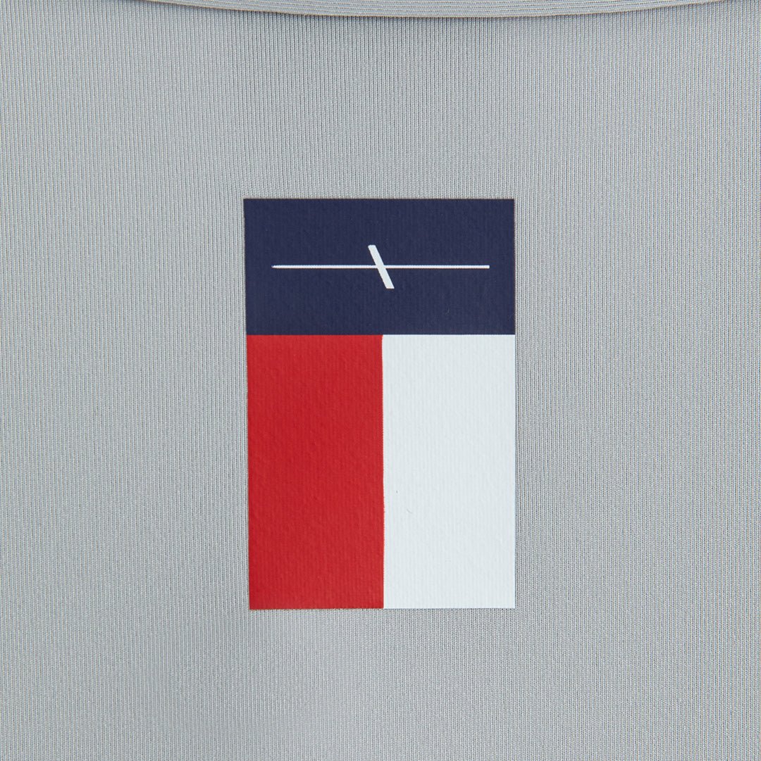 Gray polo shirt fabric close-up with navy red and white Laclavi Golf woven logo patch detail - Laclavi Golf