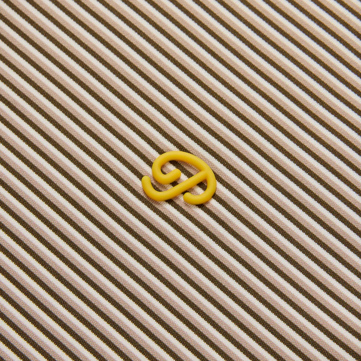 Yellow rubber band on a striped polo shirt.