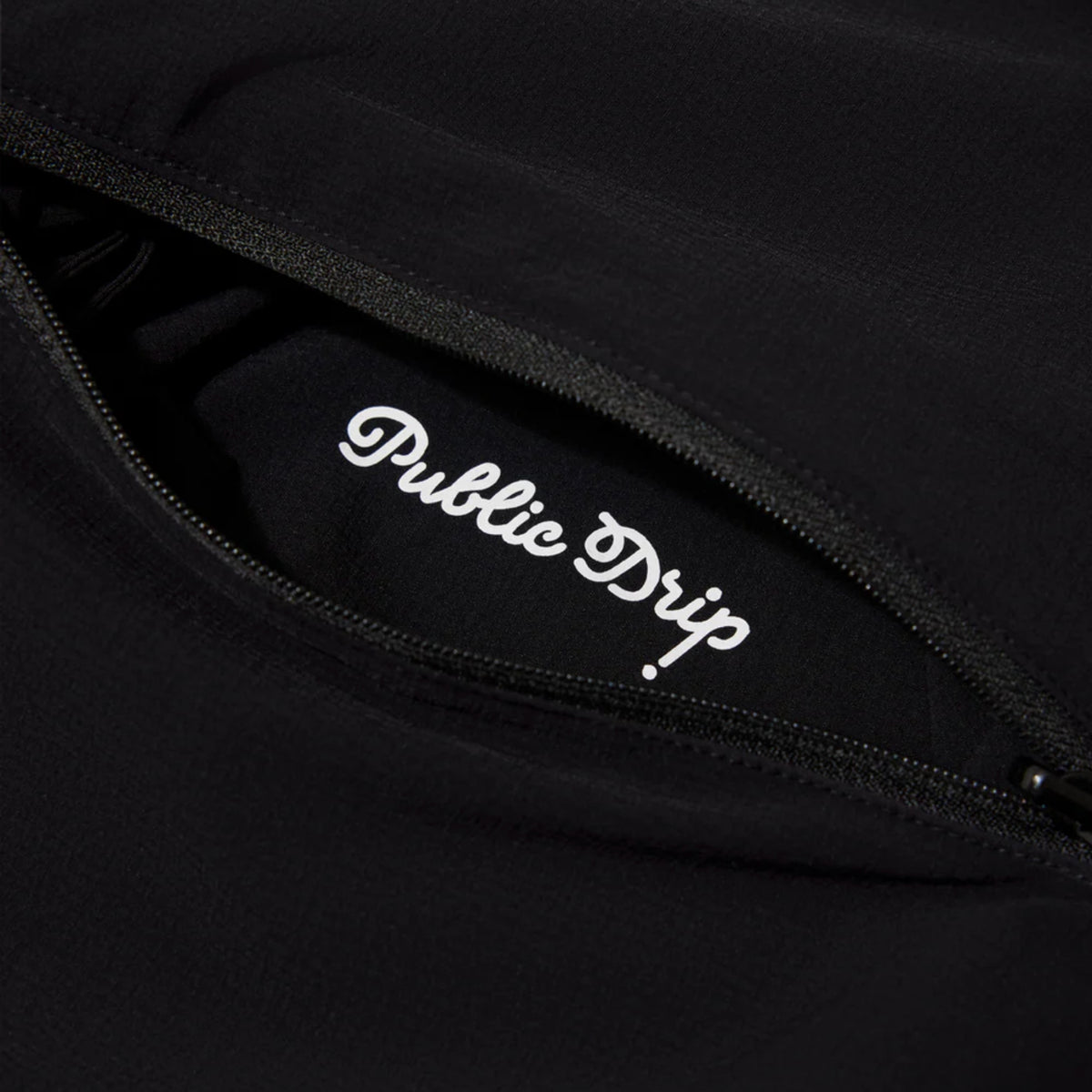 Close-up of the black shirt’s side zip pocket.