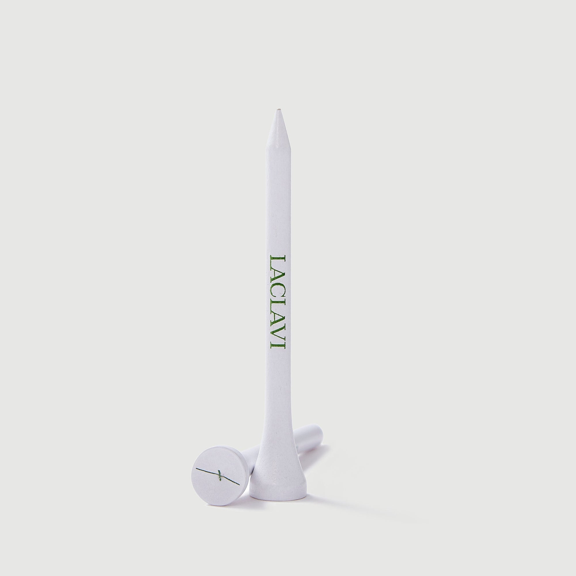 White Laclavi branded premium golf tee standing upright showing logo on cream background - Laclavi Golf