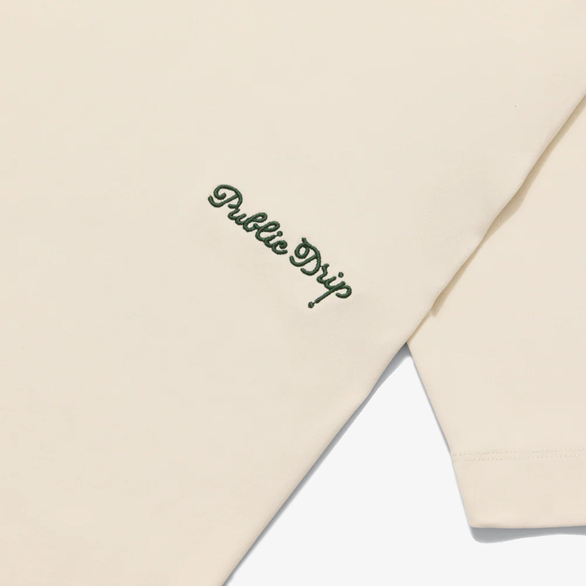 Cream t-shirt with 'Public Grip' embroidery on a white background.