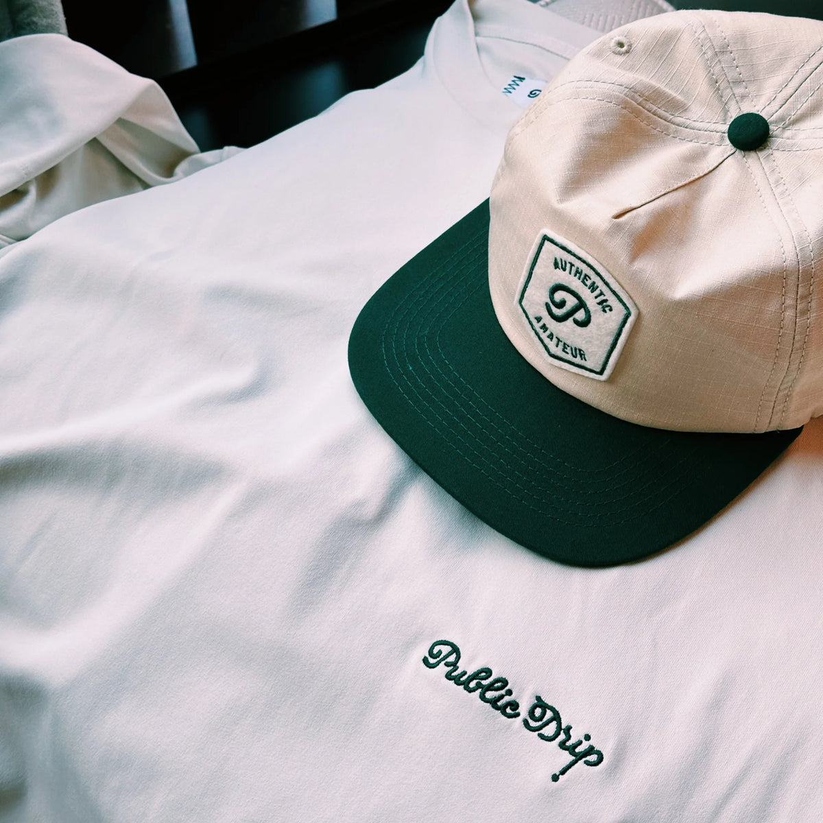 Cream t-shirt paired with a cap.