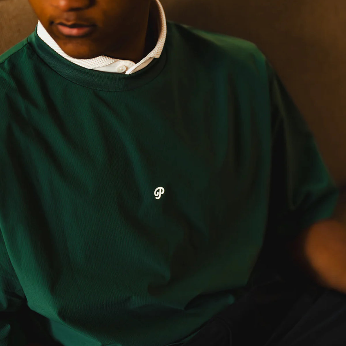 Close-up of a man wearing a green lightweight golf shirt.