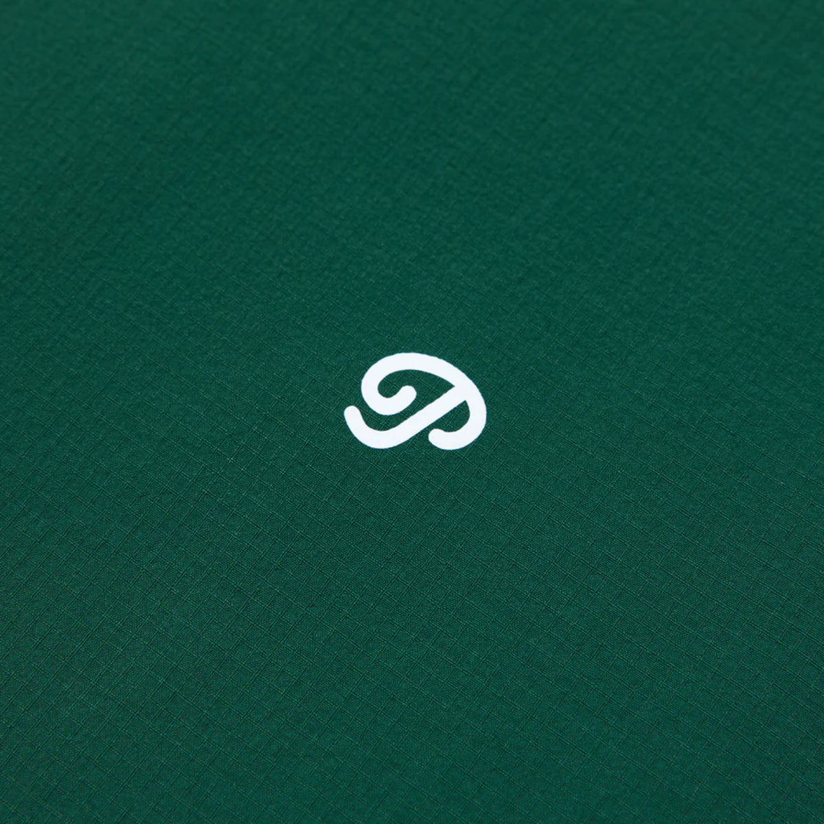 Close-up of the green golf shirt with a white logo. 