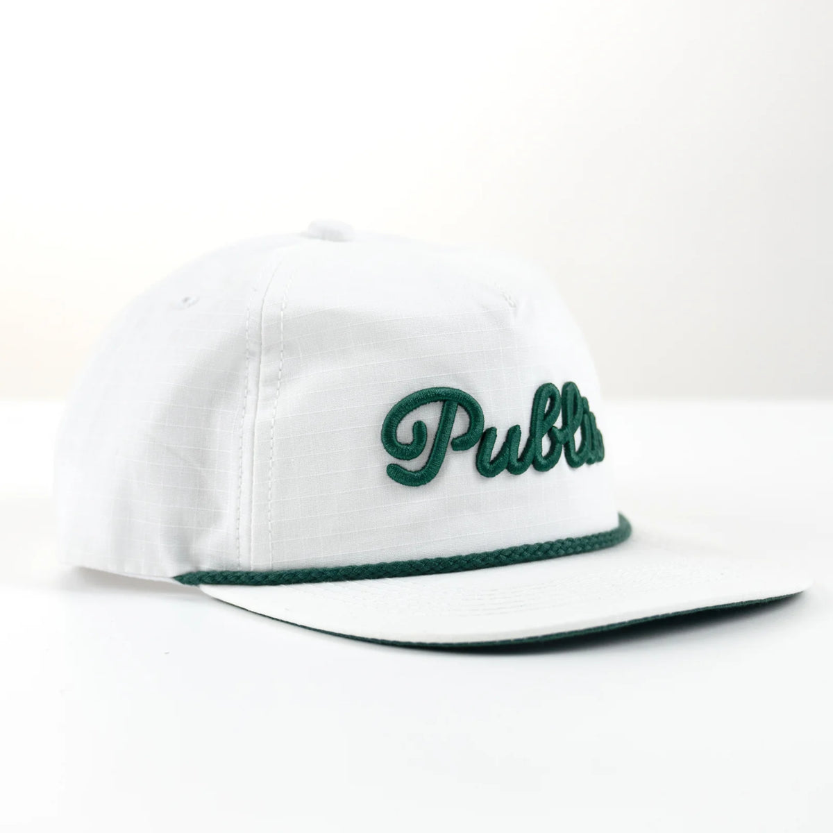 White cap with green embroidery text and rope.