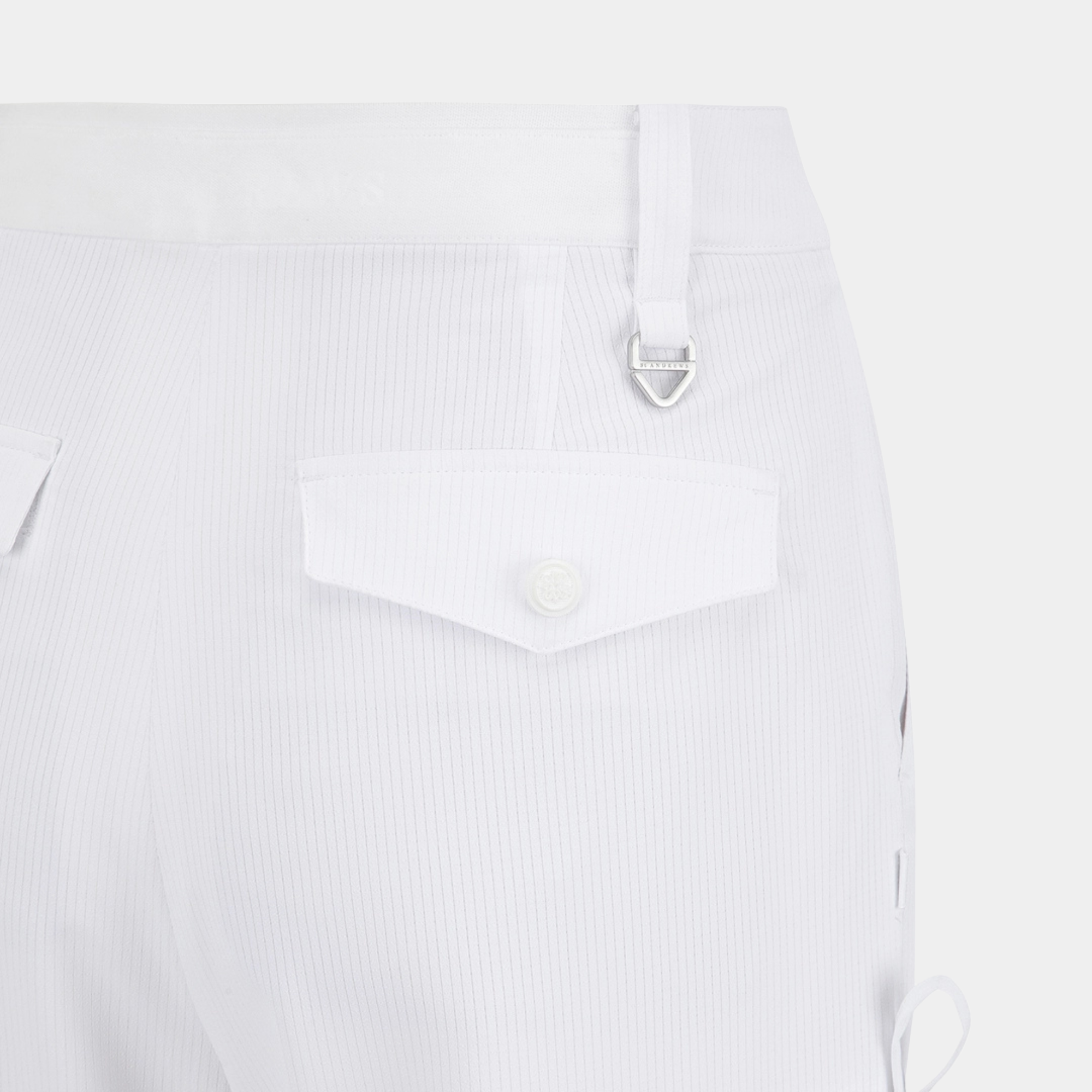 Close-up of white ribbed trousers showing a rear pocket with a button flap and a silver metal D-ring detail.