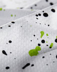 Close-up of a fabric with black and green speckles on a gray background
